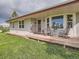 Charming home exterior featuring a wooden front porch with rocking chairs and a well manicured lawn at 50950 E 32Nd Ave, Bennett, CO 80102
