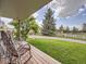Charming front yard with rocking chairs on the porch and a lush green lawn at 50950 E 32Nd Ave, Bennett, CO 80102