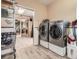 Laundry room featuring a modern washer and dryer set, with a glimpse into an adjacent room at 50950 E 32Nd Ave, Bennett, CO 80102