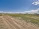 Large, fenced property with open land and sheds under a blue sky with a few clouds at 50950 E 32Nd Ave, Bennett, CO 80102