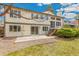 Back exterior view showing a patio, a deck with stairs, grass, and mature landscaping at 7743 S Birch Ct, Centennial, CO 80122
