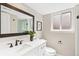 Modern bathroom with a large mirror, white vanity, and a window providing natural light at 7743 S Birch Ct, Centennial, CO 80122