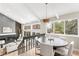 Cozy dining area next to living room with fireplace, large windows, and modern light fixture at 7743 S Birch Ct, Centennial, CO 80122