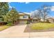 Charming two-story home with a well-manicured lawn, mature trees, and a brick-accented facade at 7743 S Birch Ct, Centennial, CO 80122