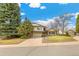 Inviting two-story home with a spacious driveway, well-kept lawn, and mature trees in a suburban setting at 7743 S Birch Ct, Centennial, CO 80122