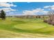 Beautiful golf course view with lush green grass, blue sky and clouds creating a serene and picturesque outdoor setting at 7743 S Birch Ct, Centennial, CO 80122