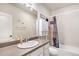 A well-lit bathroom with a shower-tub combo, white cabinets, and modern fixtures, offering comfort and style at 26903 E Easter Pl, Aurora, CO 80016