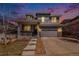 Charming two-story home with gray siding, stone accents, and a welcoming front porch at twilight at 26903 E Easter Pl, Aurora, CO 80016
