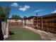 Cozy backyard featuring a well-maintained fence and artificial grass against a sunny sky at 1564 Verbena St, Denver, CO 80220