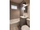 Renovated bathroom with modern gray tiling, updated fixtures, and a clean, stylish design at 1564 Verbena St, Denver, CO 80220