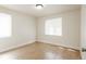 Bright, empty bedroom with wood floors and natural light from two windows at 1564 Verbena St, Denver, CO 80220