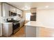 Updated kitchen with stainless steel appliances, gray cabinets, and stylish backsplash at 1564 Verbena St, Denver, CO 80220