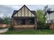 Charming two-story home featuring a classic brick facade, covered front porch, and a well-maintained lawn at 1653 Trenton St, Denver, CO 80220