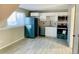 Modern kitchen with white cabinets, teal appliances, and tile floor at 18971 E Mercer Dr, Aurora, CO 80013