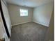 A bright bedroom with neutral walls, gray carpet, and a window with blinds at 865 S Depew St, Lakewood, CO 80226