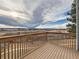 Relaxing back deck overlooks an open area with mountain views in the distance under partly cloudy sky at 1699 S Trenton St # 172, Denver, CO 80231