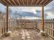 Enclosed backyard features a small patio with a pergola, a wooden gate, and views of nearby houses at 1699 S Trenton St # 172, Denver, CO 80231