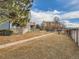 Spacious common area featuring a sidewalk, mature landscaping, and a community pool in the distance at 1699 S Trenton St # 172, Denver, CO 80231