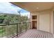 View of the outdoor balcony, with wood-style floors, black railing, and exterior nature views at 303 Inverness Way # 201, Englewood, CO 80112