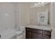 Bathroom with white tile and shower, neutral walls, tile floors, and a dark wood vanity at 303 Inverness Way # 201, Englewood, CO 80112