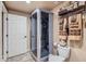 Modern bathroom featuring a glass shower stall, neutral tile, and complementary towel and toiletry storage at 10968 Macon St, Commerce City, CO 80640