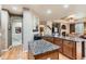 Open concept kitchen with granite countertops, wooden cabinets, hardwood floors, and modern stainless steel appliances at 10968 Macon St, Commerce City, CO 80640