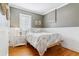 Charming bedroom featuring hardwood floors, wainscoting detail, and a cozy bed with decorative pillows at 1038 E 4Th Ave, Denver, CO 80218