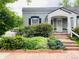 Charming gray home featuring lovely landscaping and a welcoming covered front porch at 1038 E 4Th Ave, Denver, CO 80218