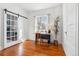 Home office features hardwood floors, a sliding barn door, and natural light at 1038 E 4Th Ave, Denver, CO 80218