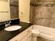 Bathroom with dark countertop and tile backsplash at 3124 S Wheeling Way # 102, Aurora, CO 80014