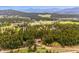 Expansive aerial view of a private home nestled in a lush forest with mountains in the distance at 25808 Sunrise Ln, Golden, CO 80401