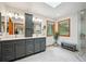 Bright bathroom with double vanity, skylight, and glass-enclosed shower offers a spa-like experience at 25808 Sunrise Ln, Golden, CO 80401