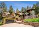 Charming home featuring a multi-level deck, natural stone accents, and lush landscaping at 25808 Sunrise Ln, Golden, CO 80401