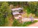 Aerial view of a wooded home with large deck surrounded by trees at 25808 Sunrise Ln, Golden, CO 80401