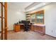Functional home office featuring a large window with natural light, a modern desk setup, and practical shelving at 25808 Sunrise Ln, Golden, CO 80401