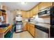 A compact kitchen featuring stainless steel appliances and wooden cabinetry at 25808 Sunrise Ln, Golden, CO 80401