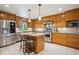Well-lit kitchen featuring stainless steel appliances, island, granite countertop, and ample cabinet space at 25808 Sunrise Ln, Golden, CO 80401
