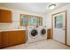 Laundry room with large capacity machines and backyard views at 25808 Sunrise Ln, Golden, CO 80401