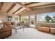 Spacious living room boasts vaulted ceilings, exposed beams, large windows with outside views, and a comfortable leather sofa at 25808 Sunrise Ln, Golden, CO 80401