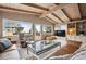 Inviting living room featuring vaulted ceilings, exposed beams, large windows, and comfortable seating with outside views at 25808 Sunrise Ln, Golden, CO 80401
