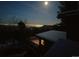 Scenic night view from a home, showcasing a city skyline under a full moon and starry sky at 25808 Sunrise Ln, Golden, CO 80401