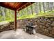 Covered patio featuring a stone wall and barbecue grill at 25808 Sunrise Ln, Golden, CO 80401