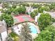 Aerial view of a community pool, tennis courts, and mature trees nestled amongst residential buildings at 14066 E Stanford Cir # H08, Aurora, CO 80015