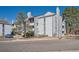 Exterior view of a gray multi-story home with balconies, landscaping, and dedicated parking at 14066 E Stanford Cir # H08, Aurora, CO 80015