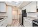 Bright kitchen featuring white cabinets, stainless steel refrigerator, and granite countertops at 14066 E Stanford Cir # H08, Aurora, CO 80015