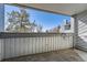 A gray patio with a view of a pine tree, chimney, and neighboring building at 14066 E Stanford Cir # H08, Aurora, CO 80015