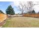 Spacious backyard with a well-maintained lawn, mature trees, and fencing for privacy at 6725 Lionshead Pkwy, Lone Tree, CO 80124