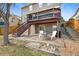 Backyard features a stone fire pit, a deck, and stairs leading to an upper level at 6725 Lionshead Pkwy, Lone Tree, CO 80124