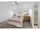 Bright bedroom featuring neutral walls, ceiling fan, and a doorway to the en-suite bath at 6725 Lionshead Pkwy, Lone Tree, CO 80124