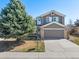 Charming two-story home features a well-manicured front yard with mature tree, and attached two-car garage at 6725 Lionshead Pkwy, Lone Tree, CO 80124